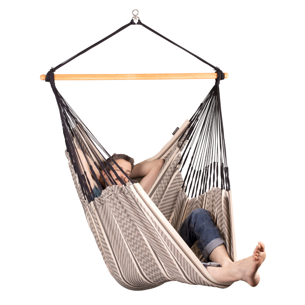 man laying back in a black and white hanging chair