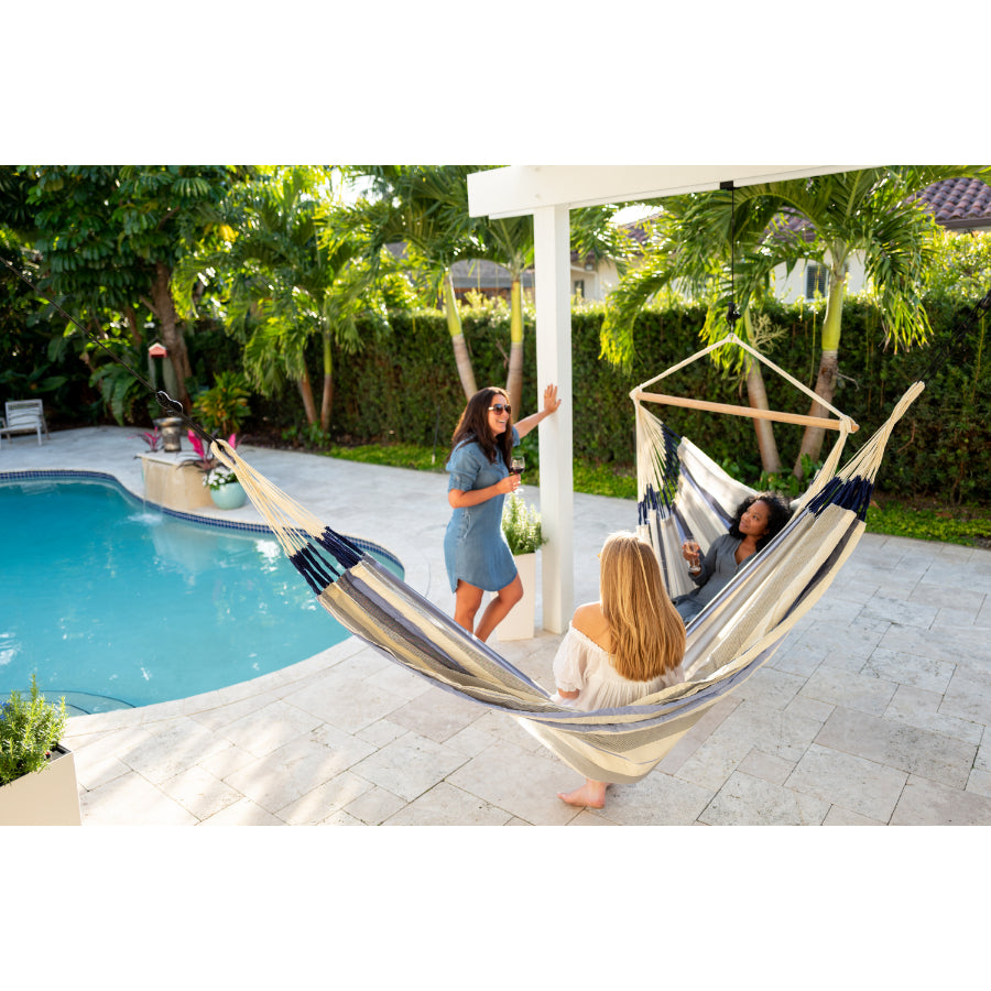 Woman chatting in hammocks by swimming pool