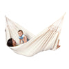 Women and child play in large white hammock
