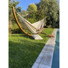 Wooden arc stand with double white cotton hammock in garden